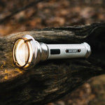 Barebones Flashlight LIV-291_Vintage_zaklamp_SlateGray liggend op een boomstronk
