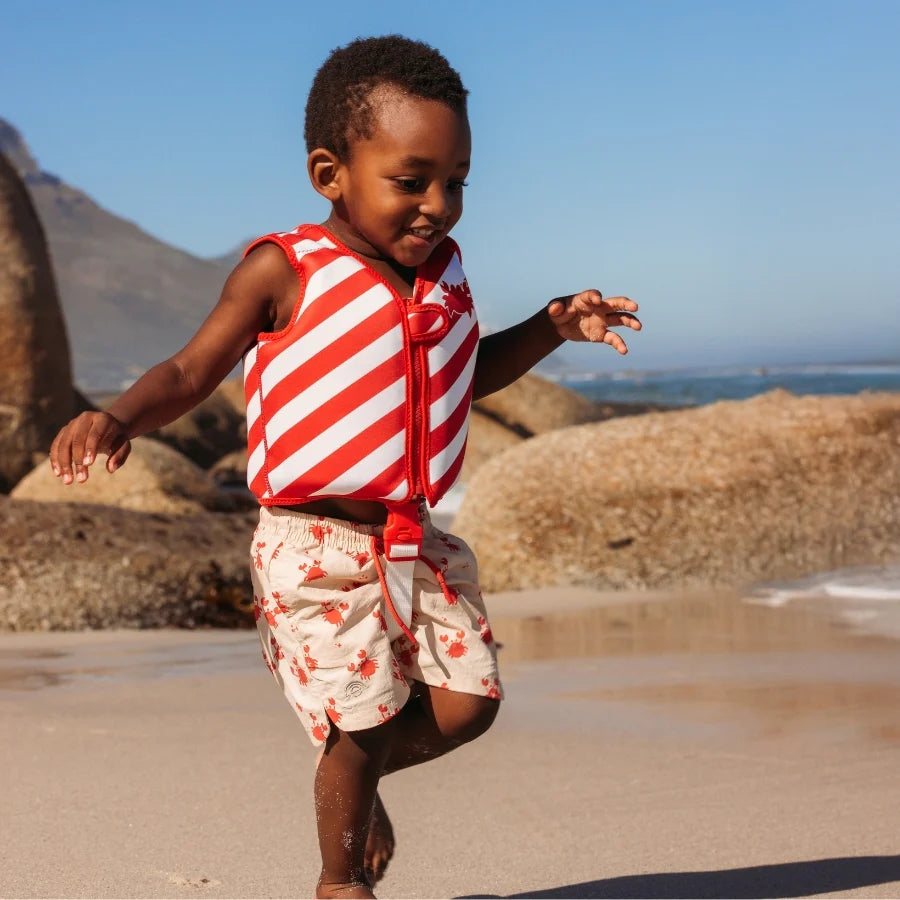 Crabby Rood/Wit Gestreept Zwemvest met jongetje die op het strand loopt