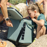 Dometic_DSC19_koeltas_moss_met_kind_die_iets_uit_de_koeltas_haald_terwijl_de_op_de_rotsen_zit