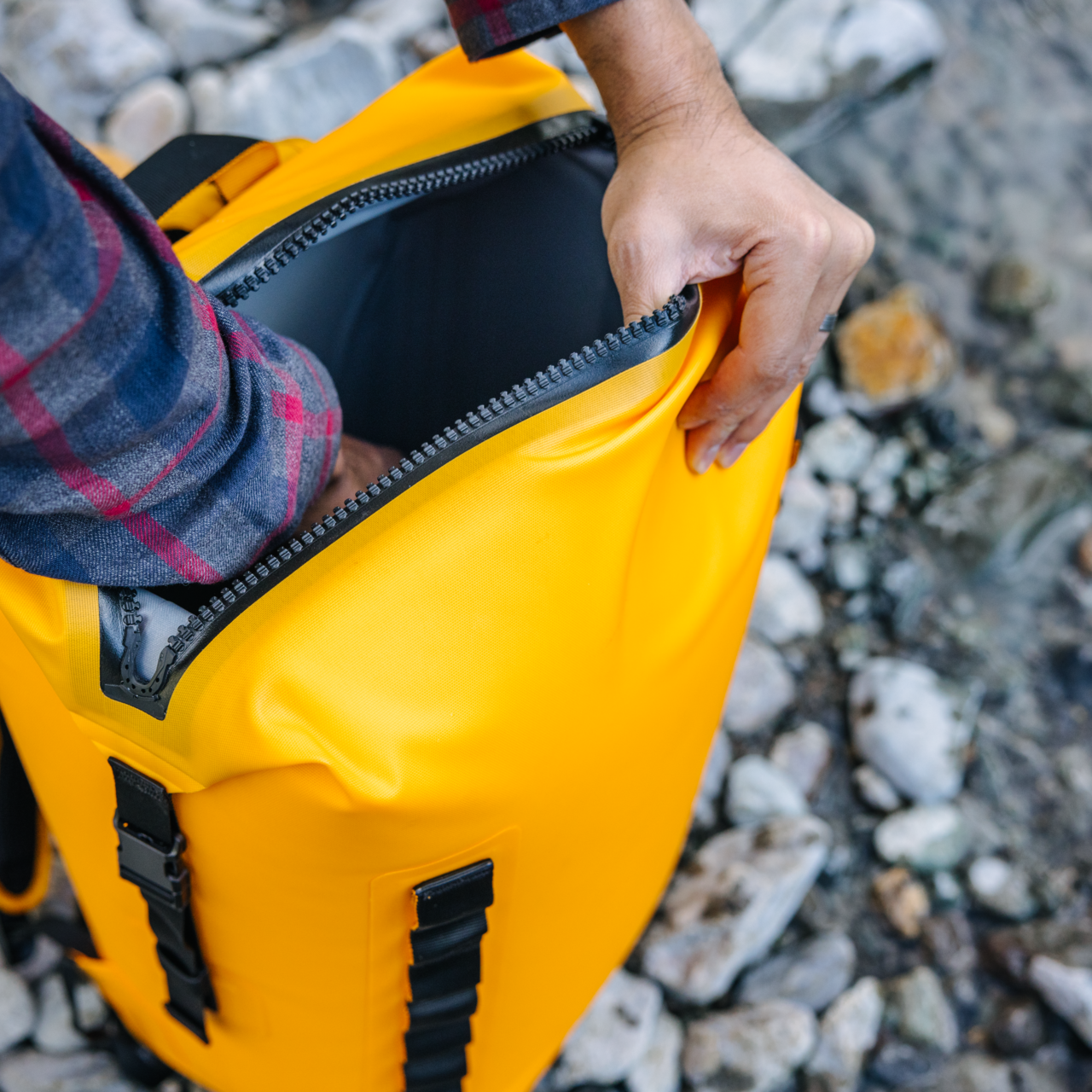 Dometic PSC22BP koelrugzak – waterdichte koeltas backpack 22L in kleur Glow geopend door een wandelaar die via de bovenzijde spullen pakt