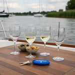 Flamefield Clear series glazen breukbestendig acryl vier stuks op een tafel aan boord van een boot met een sleutelhanger van Flamefield ernaast