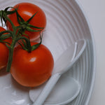 Flamefield Granite Pearl salade set – 3-delig ovaal melamine met wit ribbel design detail van de slalepel en vork met drie tomaten erop