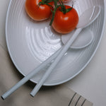 Flamefield Granite Pearl salade set – 3-delig ovaal melamine met wit ribbel design ingezoomd op de slalepel en vork met twee tomaten erop