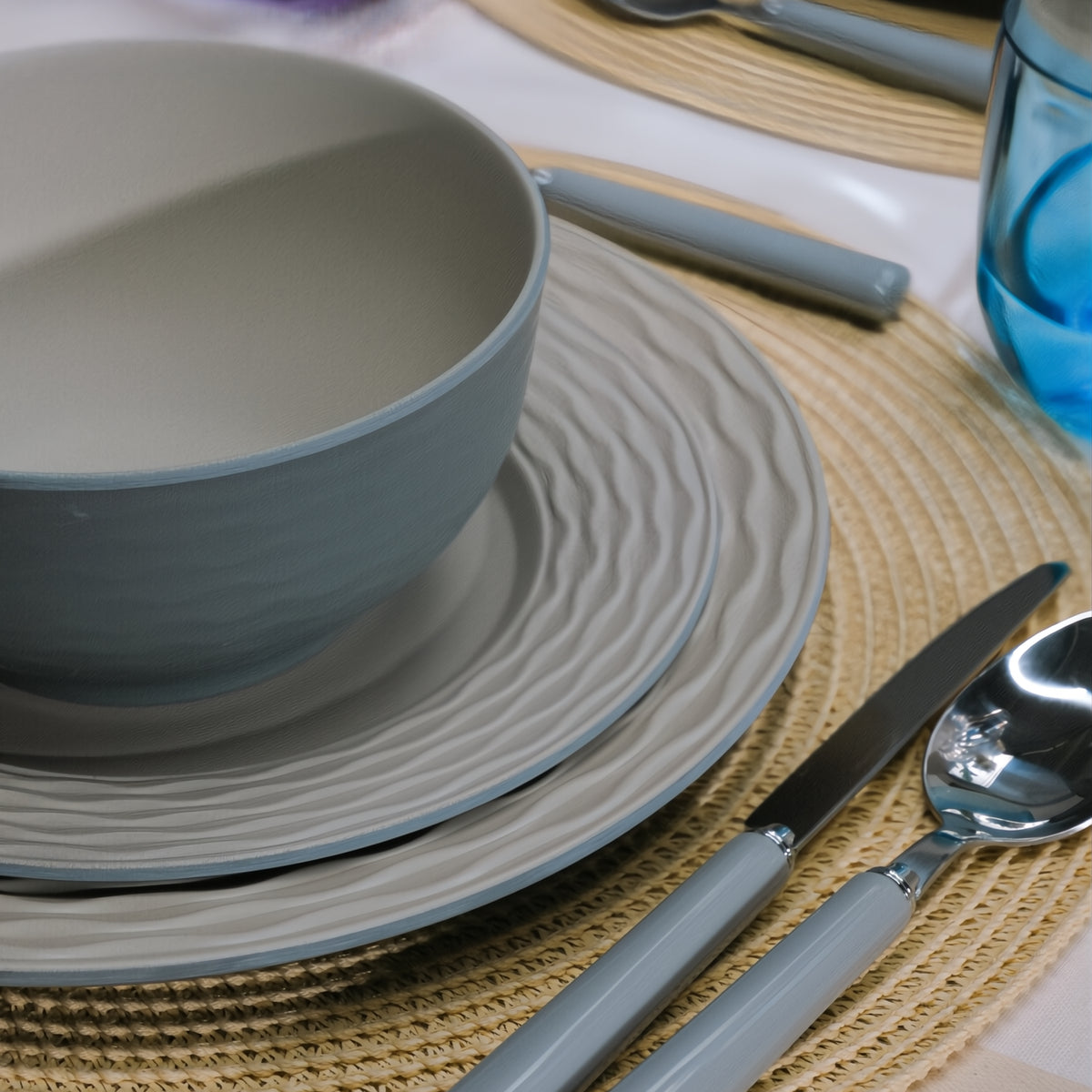 Flamefield Ripple Sand RS0112 melamine servies zand, grijs, natuur relief, in sfeerbeeld met bestek en placemat ingezoomd op relief van de borden