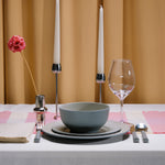 Flamefield Ripple Sand RS0112 melamine servies zand, grijs, natuur relief, in sfeerbeeld met glas wijn kaarsen en gedekte tafel met okergeel gordijn