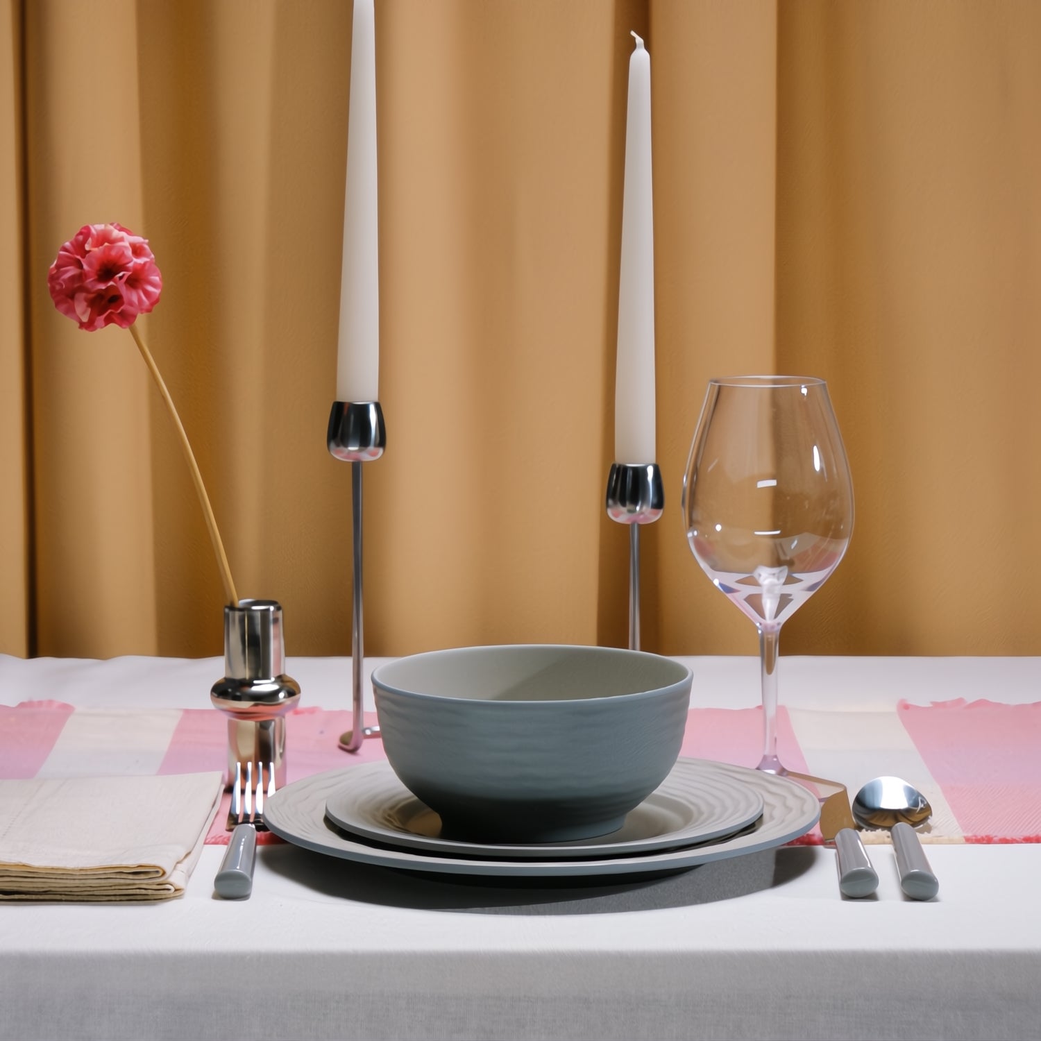 Flamefield Ripple Sand RS0112 melamine servies zand, grijs, natuur relief, in sfeerbeeld met glas wijn kaarsen en gedekte tafel met okergeel gordijn