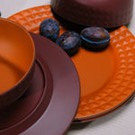 Flamefield Viva Terra melamine servies borden en kommen gemixt door elkaar in bordeaux, rood ingezoomd met dadels