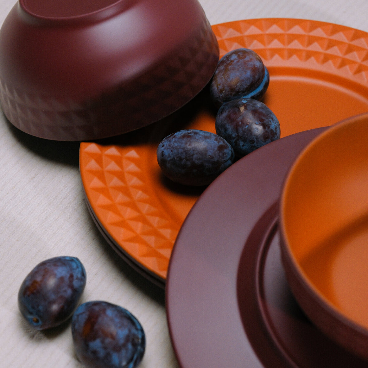 Flamefield Viva Terra melamine servies borden en kommen gemixt door elkaar in bordeaux, rood ingezoomd met druiven 