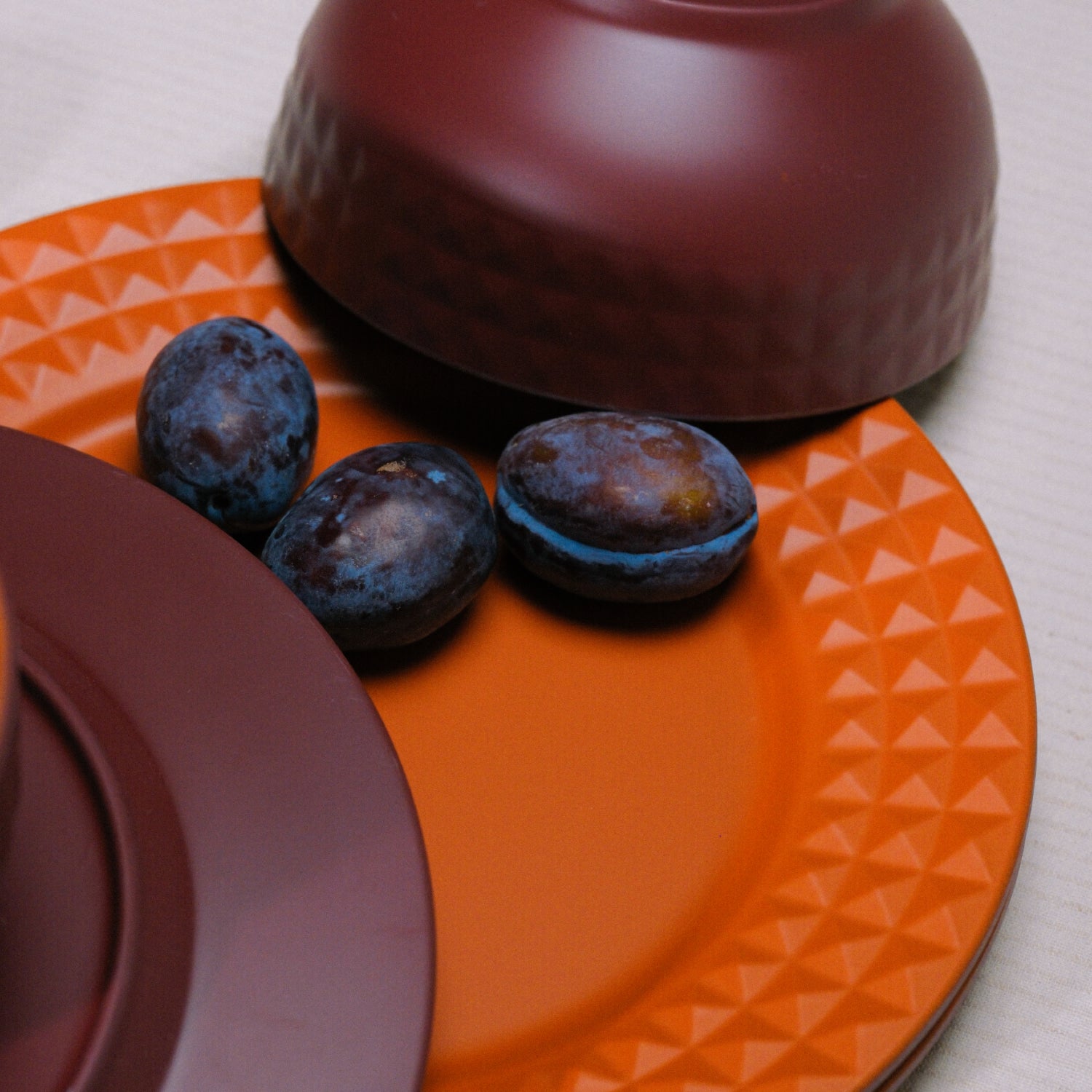 Flamefield Viva Terra melamine servies – licht, reliefrand, bordeaux, rood detail sfeerbeeld van relief, kleuren met dadels op een bord