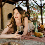 Flamefield_crcouw_op_kleed_liggend_met_wijnglas_Gobelt_met_rode_wijn_erin