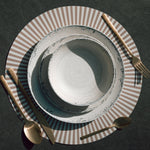 Flamefield serviesset Rustic Pearl – 12-delig melamine servies dinerbord, otbijtbord, kom, op een gestreepte placemate met bestek van bovenaf gefotografeerd 