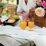 Flamefield twee stuks slim Jim clear met sinaasappel appelsap met een picknick mand op de achtergrond