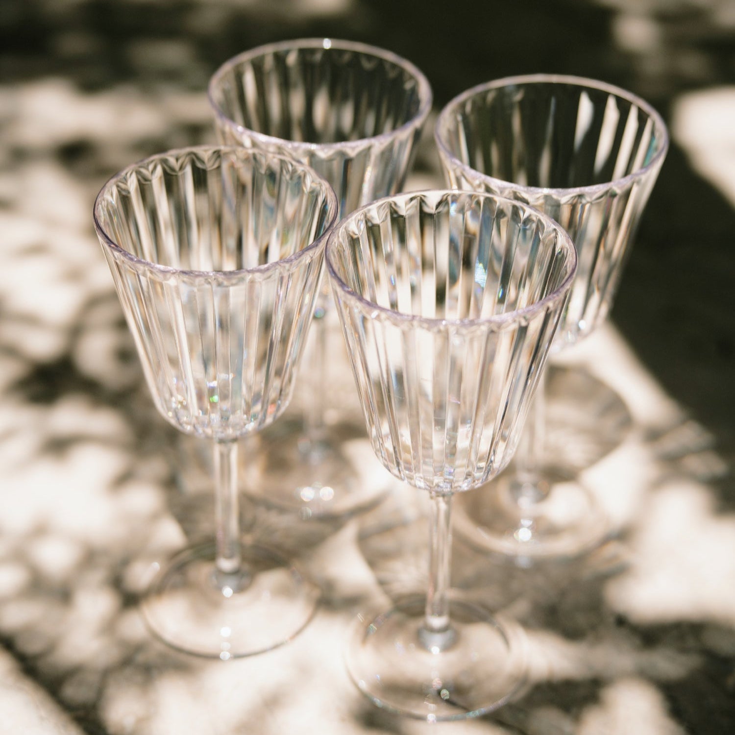Flamefield_vier_glazen_uit_Crystal_serie_gefotografeerd_buiten_in_de_zon_met_schaduw_erop_vallend
