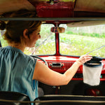 Flextrash_Small in keur Casual Creme hangend in een rode camper met een vrouw achter het stuur