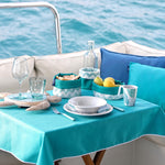 Harmony Mare Blue melamine servies - wit met koraaldecoratie en parelrand samen met opbergmanden en beker en glaswerk op tafel
