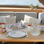 Harmony Mare Coral melamine servies - wit met koraaldecoratie en parelrand met bijpassende glazen en bekers op gedekte tafel aan luxe jacht