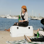 IGLOO_contour_koolbox_met_een_dame_die_op_de_koolbox_zit_aan_het_strand