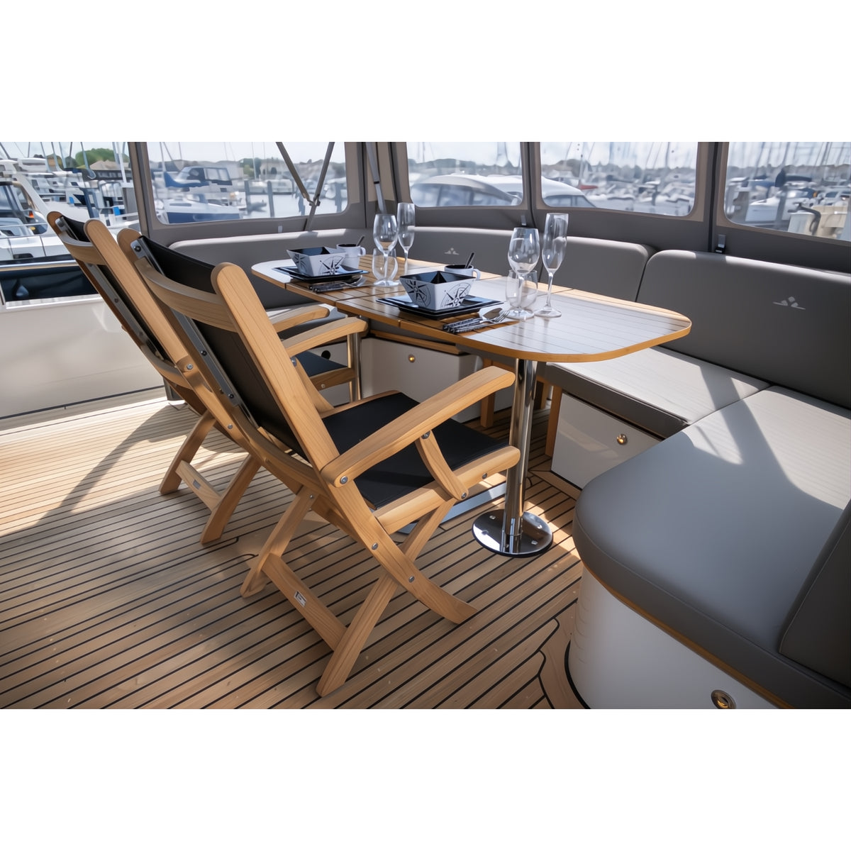 Luxe comfortabele teak klapstoelen voor outdoor gebruik, sfeerfoto op luxe boot, met bijpassende teak tafel en servies