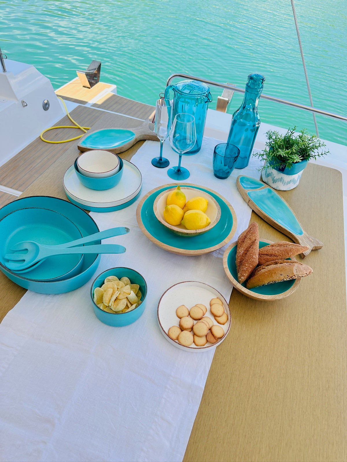 Maldivas bootservies Acqua met bootservies wit, en schalen van hout aan boord van een jacht, sfeersetting op tafel
