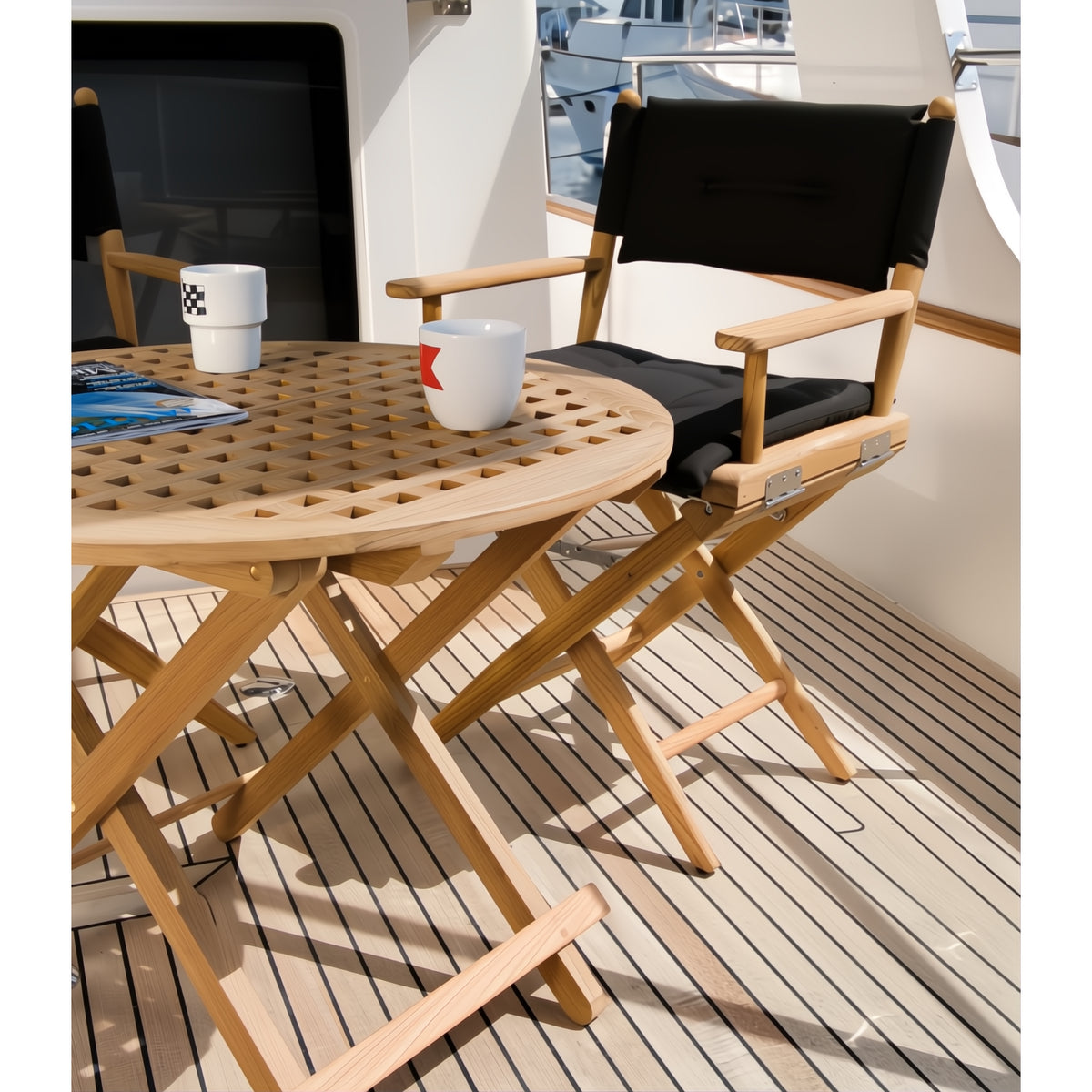 Regisseursstoel_I_deluxe_-_geolied_teak_met_zwarte kussens aan teaktafel