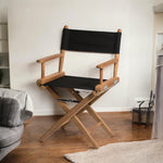 Regisseursstoel I met canvas zitting, ongeolied teak en zwarte bekleding in sfeersetting binnen interieur
