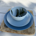 SB0112 Flamefield onbreekbaar servies Shades of Blue op een houten bord met een olijftakje in de kom