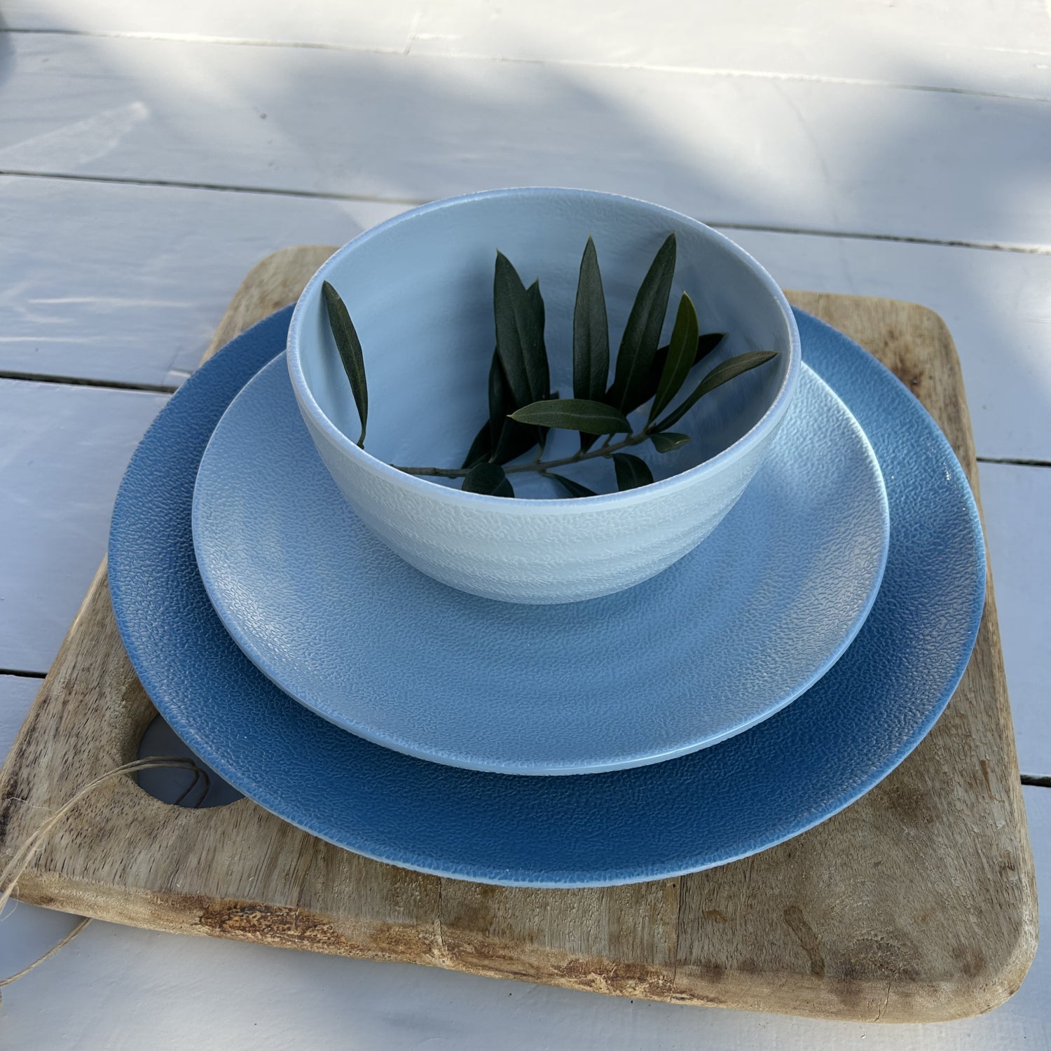 SB0112 Flamefield onbreekbaar servies Shades of Blue op een houten bord met een olijftakje in de kom