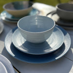SB0112 Flamefield onbreekbaar servies Shades of Blue op een tafel met meerdere serviezen