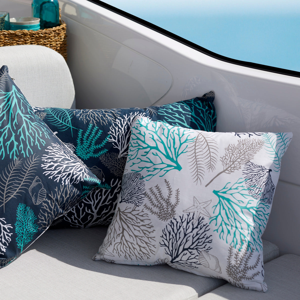 Sierkussen Ibiza van Marine Business wit vierkant samen met twee blauwe Ibiza kussens in de boot