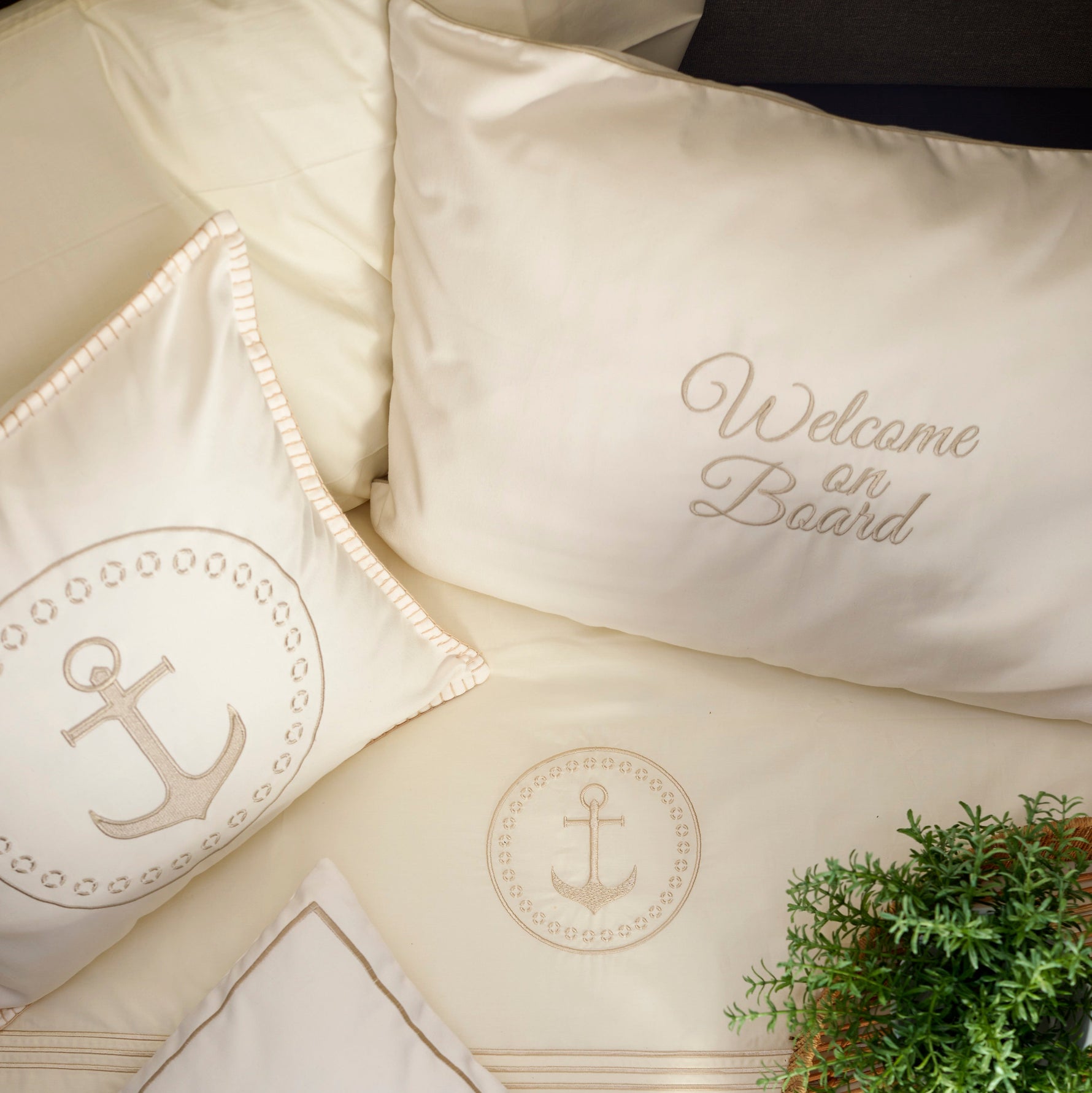 Sierkussen set (2 stuks) – nautisch design met ‘Welcome on Board’ borduursel in cabinroom aan boord, samen met het Santorini beddengoed ecru foto van bovenaf genomen