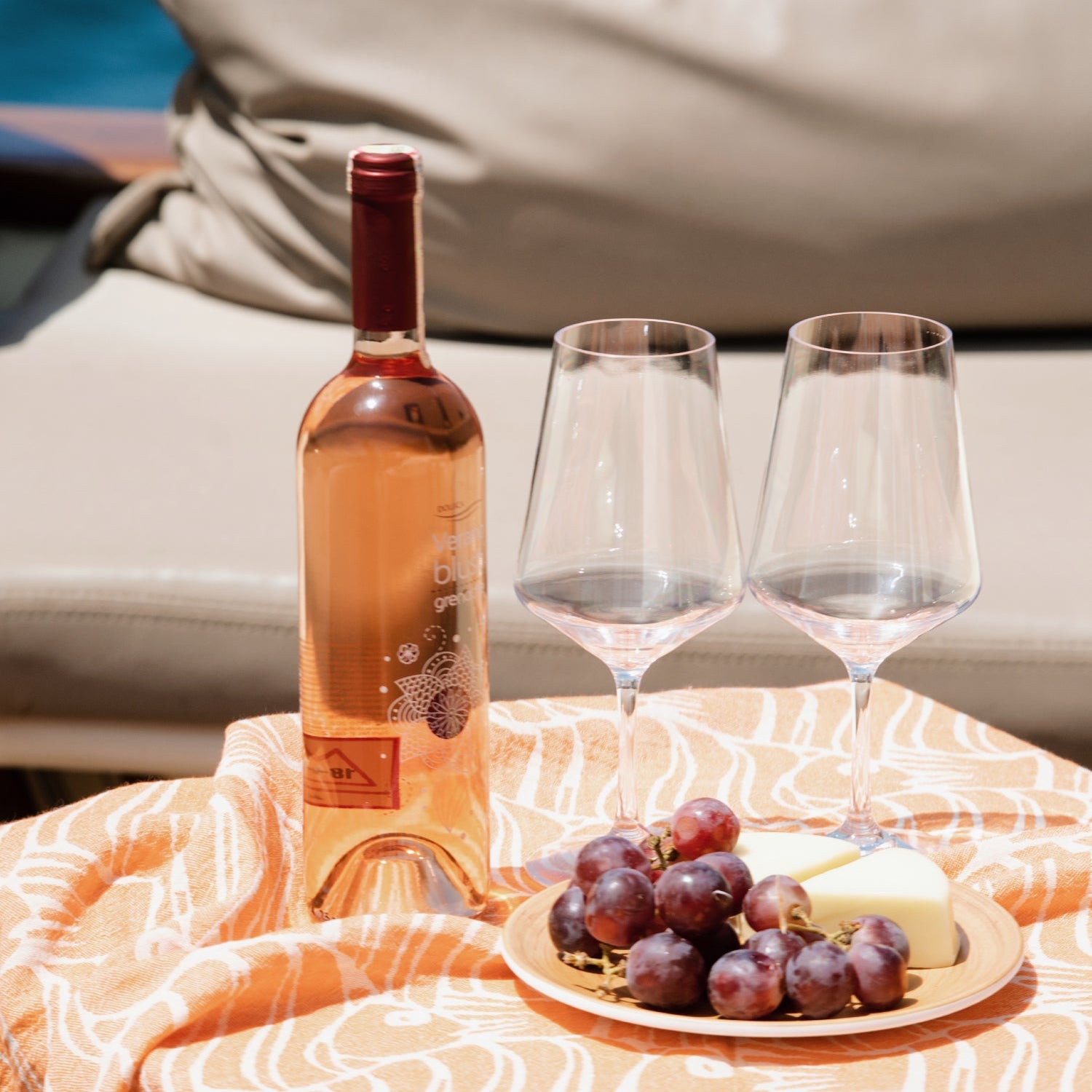 Twee wijnglazen van Savoy serie van Flamefield op een tafel met een fles rose en schaaltje met druiven en kaas aan boord van een boot