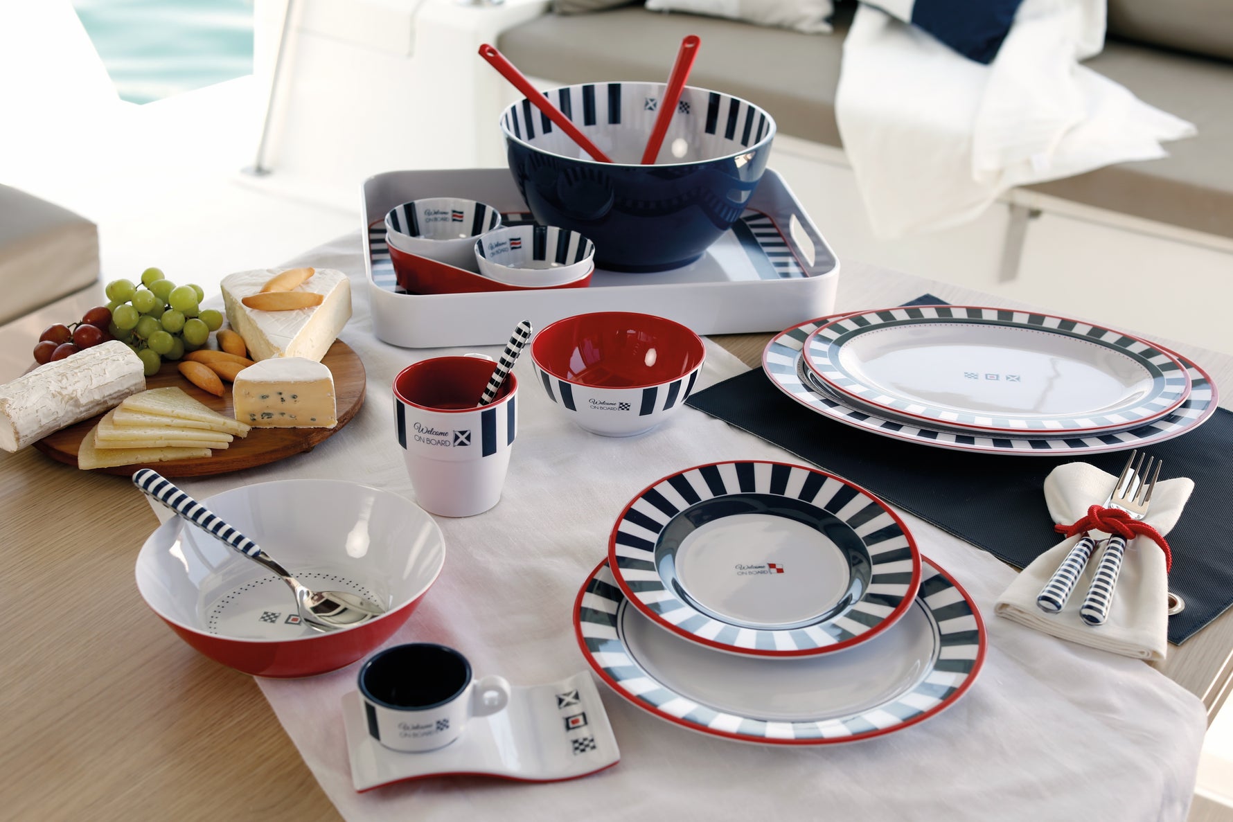 Venezia bootservies - wit met navy gestreept en rode accenten gemixt met accessoires en eten op tafel op een boot 
