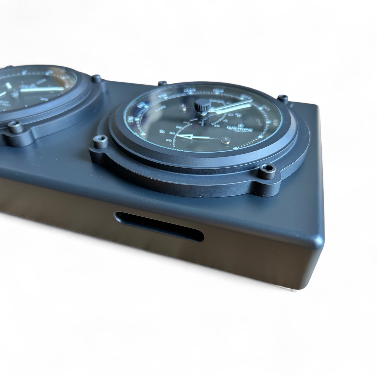 Wempe_Navigator_II_combinatie-instrument_-_klok_weerstation_zwart_aluminium_rechthoekig ingezoomd van schuin onder gercicht op de inkeping aan de onderzijde