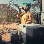 Woman with a bicycle helm holding the domestic off-35 coolbox