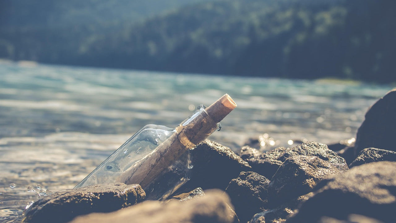 flessenpost fles met brief erin op rots aan zee als afbeelding voor ons retourbeleid