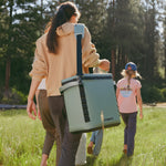 vrouw_met_kinderen_die_in_een_veld_lopen_met_een_hometic_psc19_koeltas_moss_op_haar_schouder