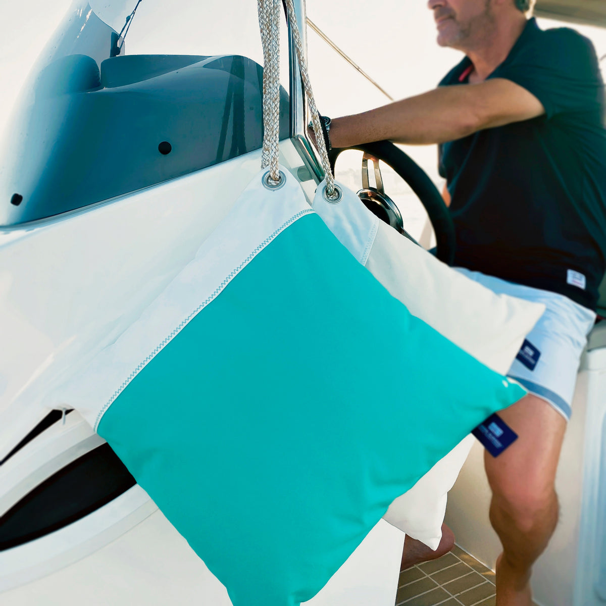 waterproof_kussens in de kleuren acqua en sand met wit, hangend aan de stuurkolom van een boot